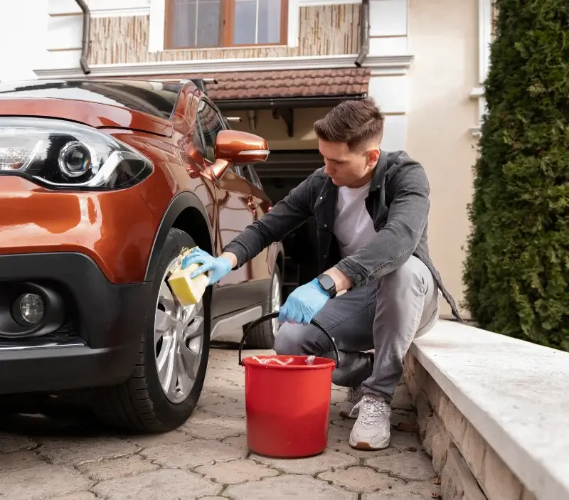 Lavage auto à domicile Gauville-la-Campagne : professionnel intervenant sur un véhicule